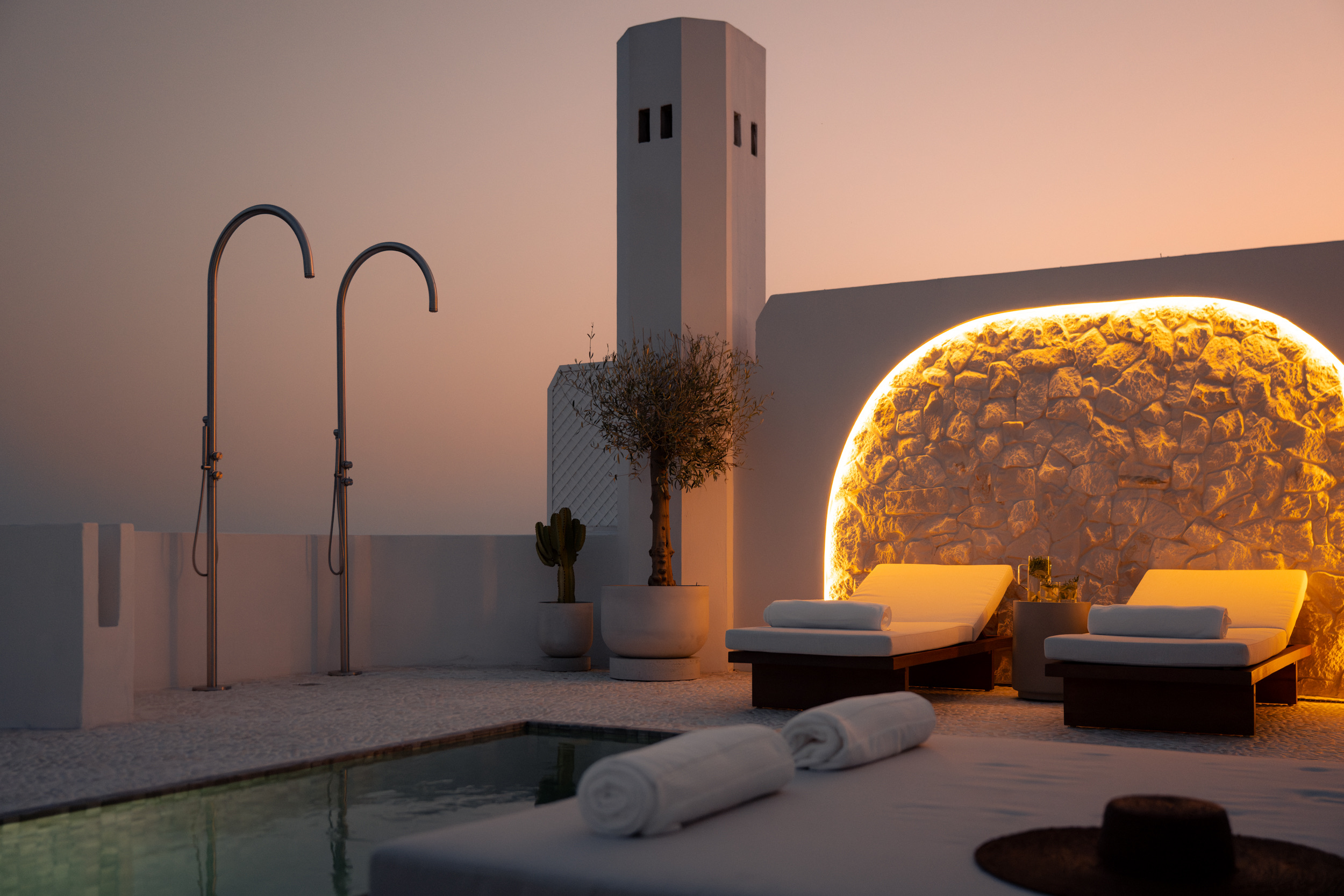 Oía Penthouse rooftop lounge and illuminated stone arch